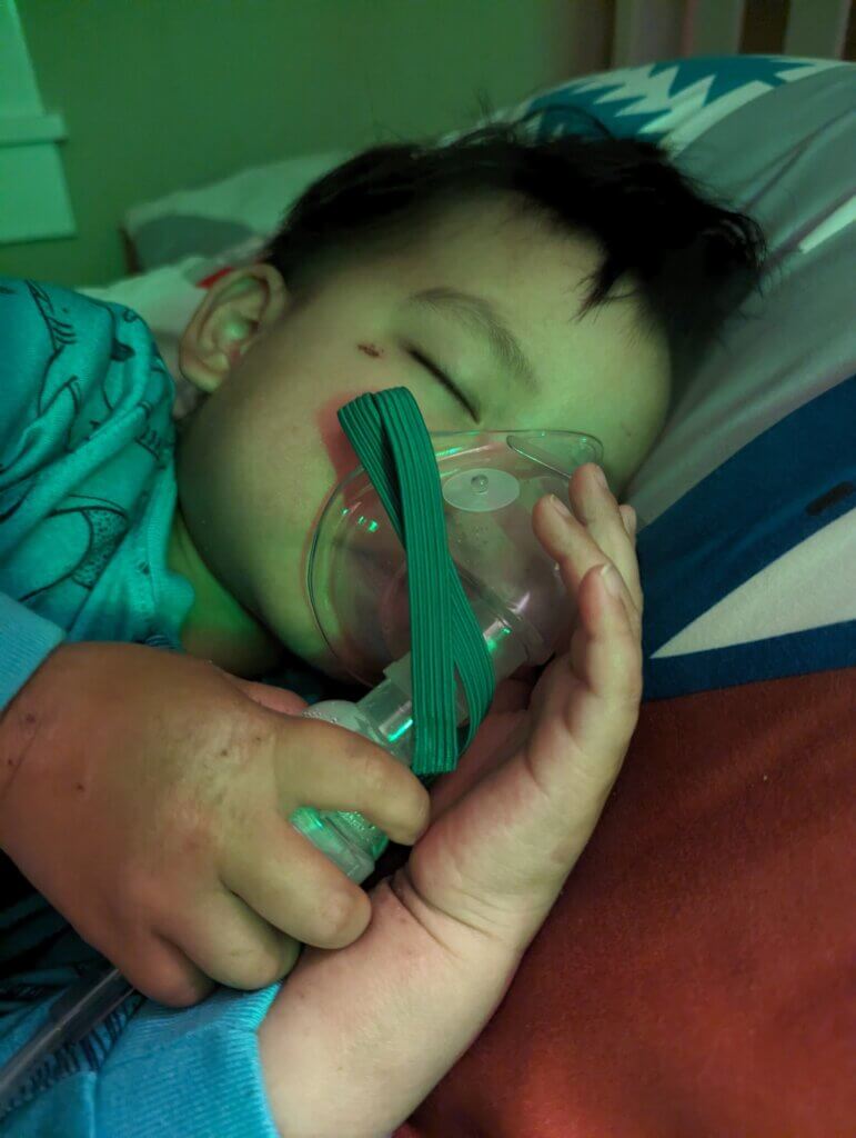 The youngest learning how to use his breathing machine while sleeping
